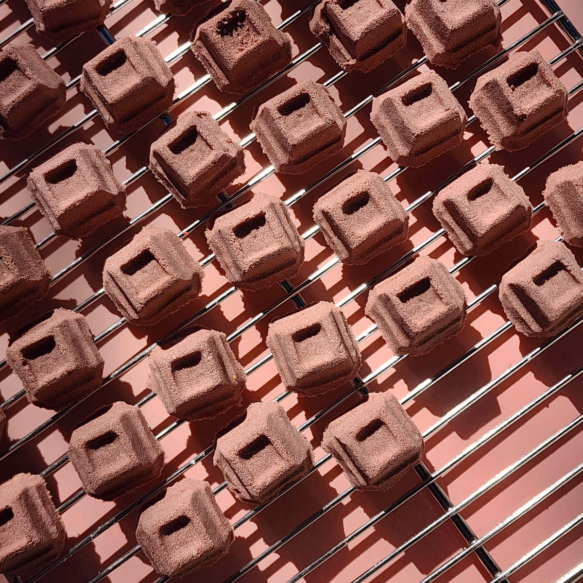 mini chocolate bath bombs shaped like cubes of chocolate on a plain brown background