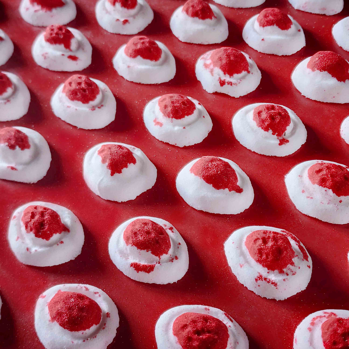 Mini red and white bath bomb inspired by the berry and cream soft lolly from the classic australian party mix