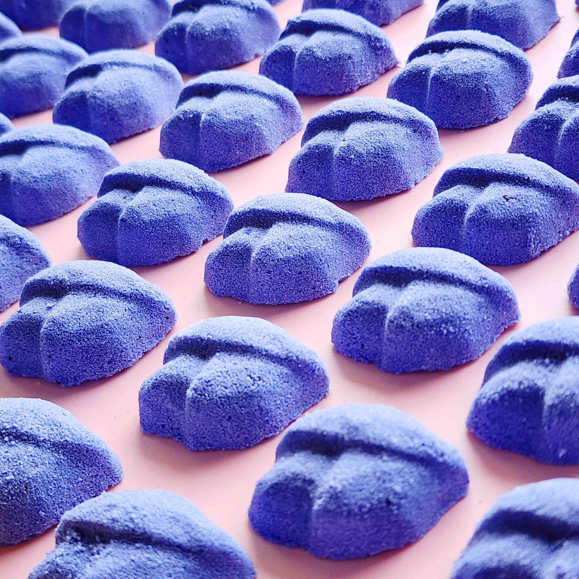 Close-up rows of purple lip-shaped Lavender mini bath bombs