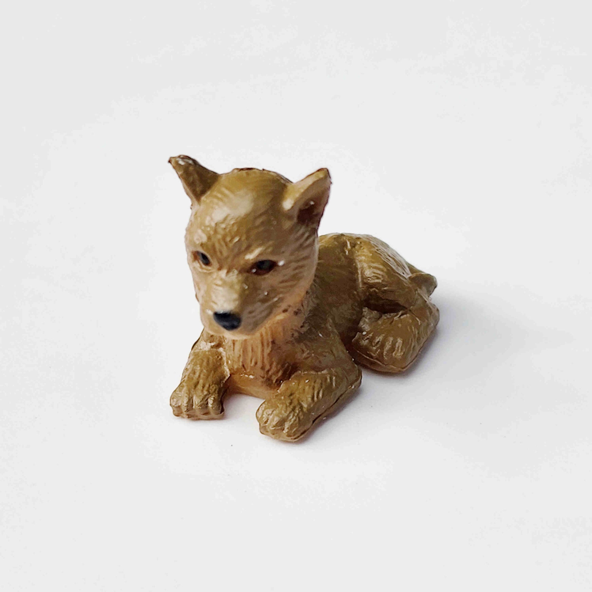 Brown puppy dog figurine placed on a plain white background