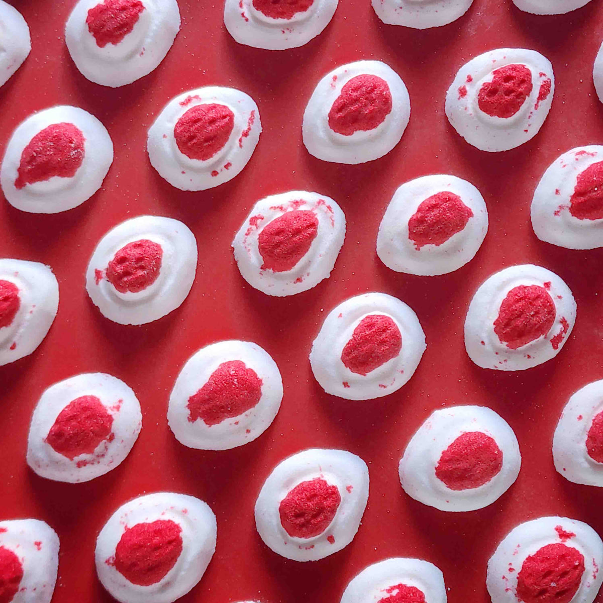 Mini red and white bath bomb inspired by the berry and cream soft lolly from the classic australian party mix