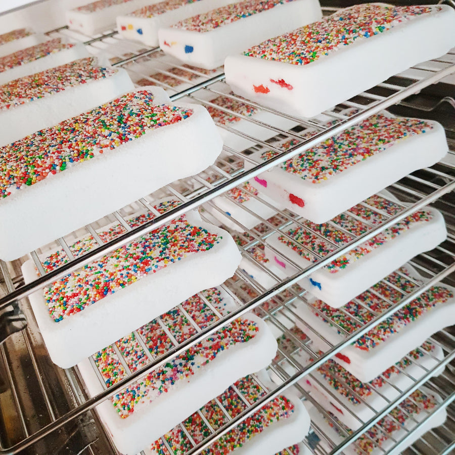 Fairy bread bath bombs cooling on studio racks