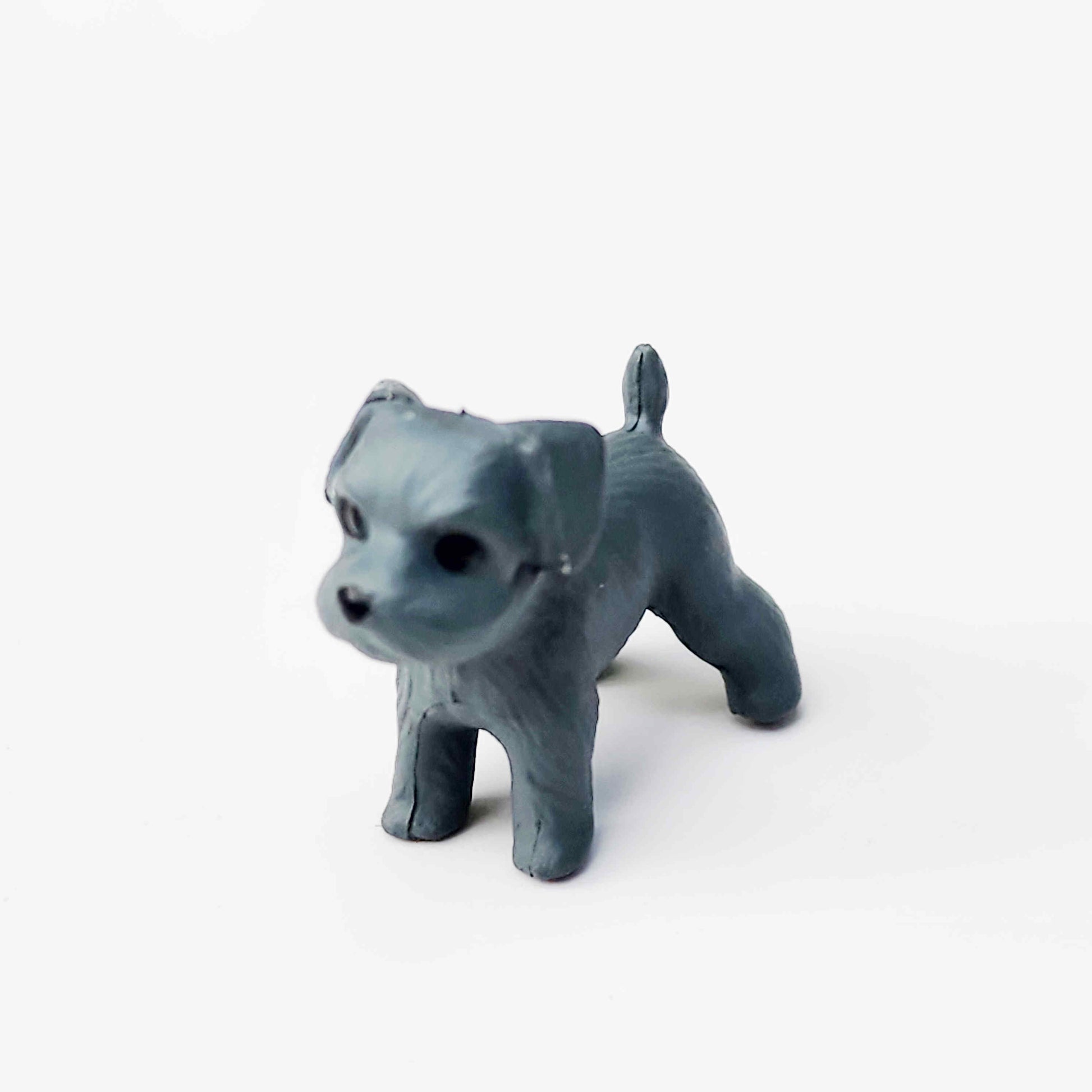 a charcoal coloured scottish terrier figurine made of pvc on a plain white background