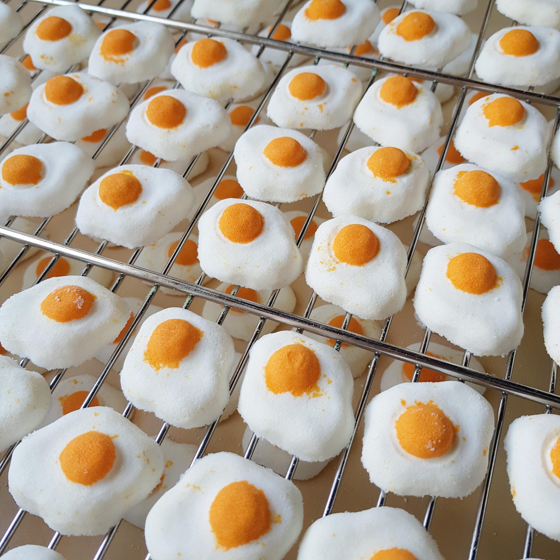 Mini sunny side up egg shaped bath bomb with a golden orange yolk