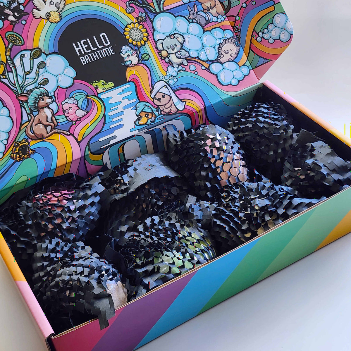 Open rainbow Oopsie Surprise Box packed with protected bath bombs