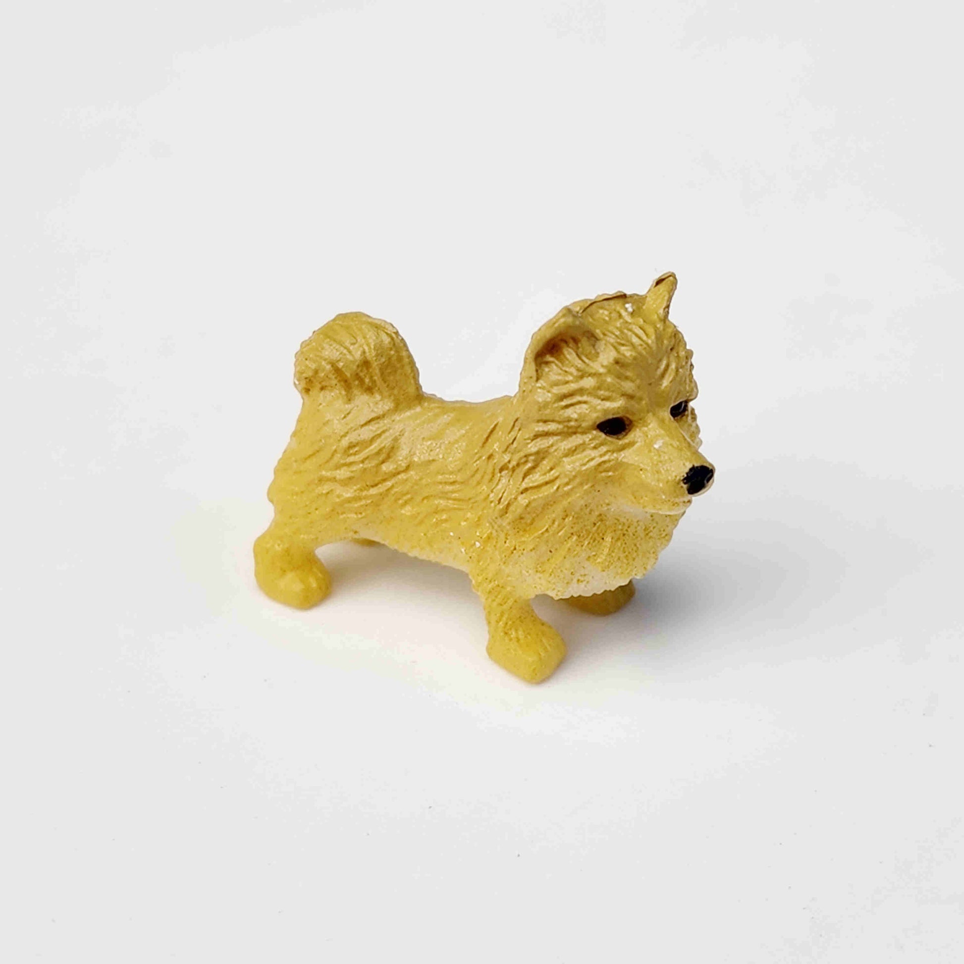 beige coloured pvc dog figurine on a white background