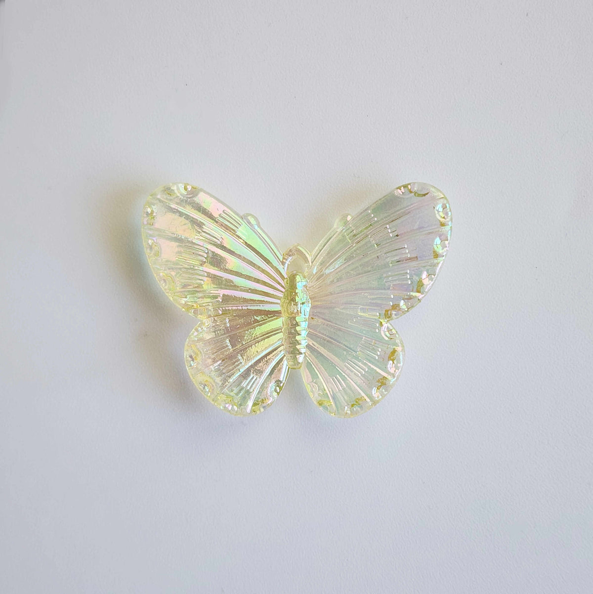 faintly yellow pigmented clear iridescent butterfly charm