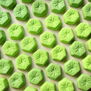 Green kiwi-slice mini bath bombs arranged in rows