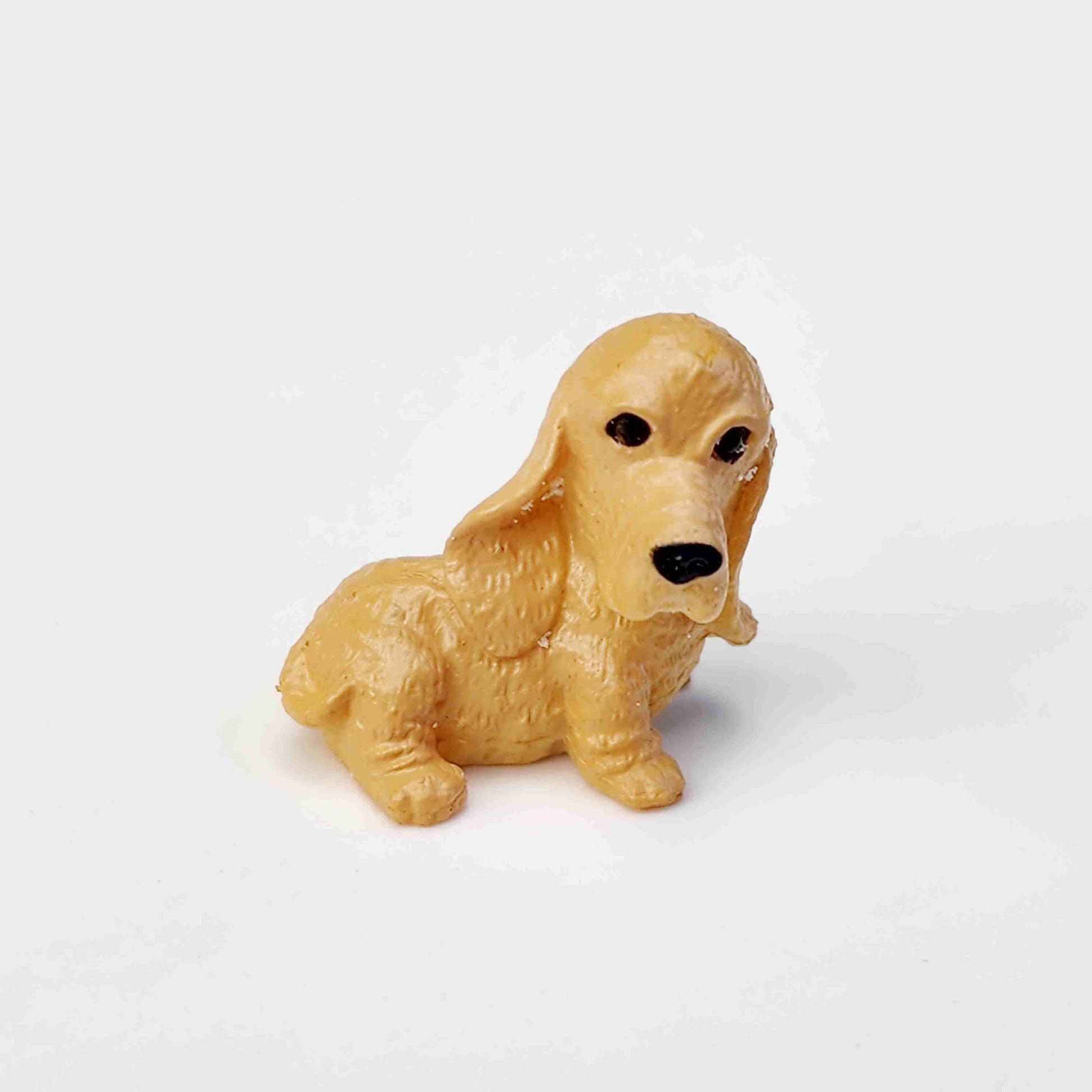 beige coloured pvc dog figurine on a white background