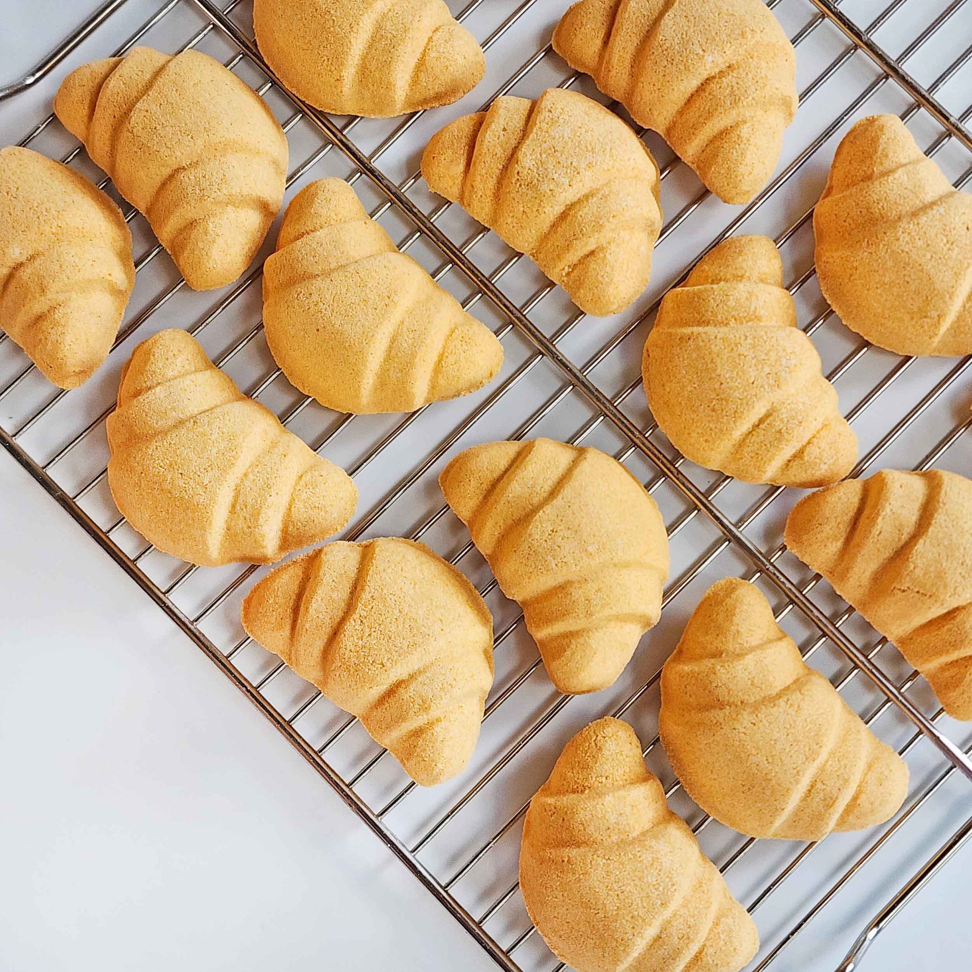 Croissant bath bombs arranged on a cooling rack