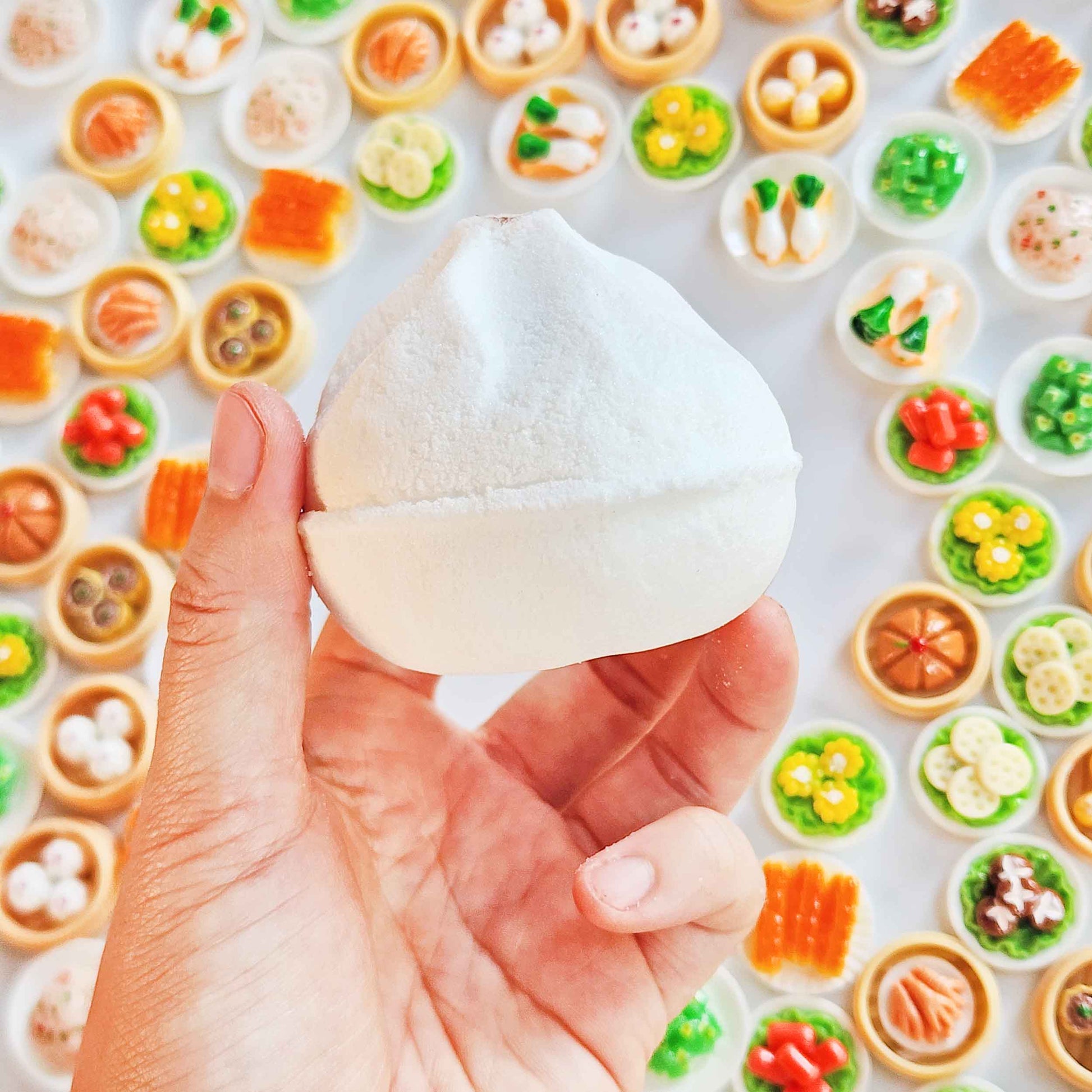 Side view of a white Yum Cha bao bath bomb held in one hand