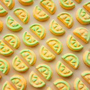 Yellow and green honeydew-slice mini bath bombs arranged in rows