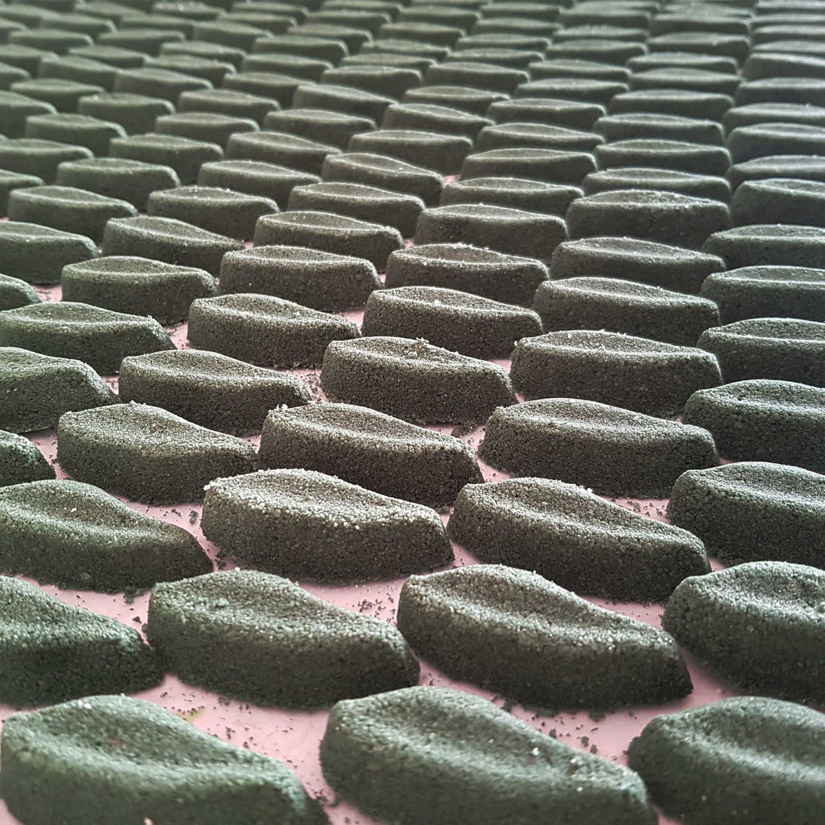 deep green long leaf shaped bath bombs laid out neatly on a plain white background