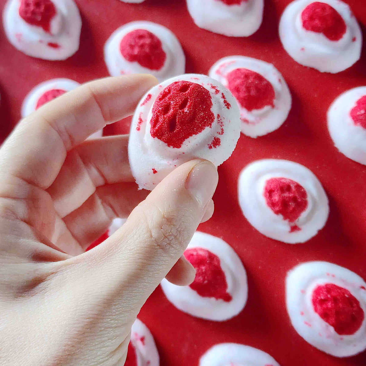 Mini red and white bath bomb inspired by the berry and cream soft lolly from the classic australian party mix
