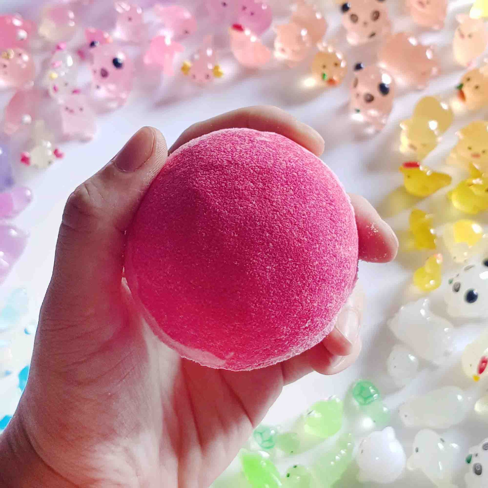 Hand holding the smooth pink top of a mushroom bath bomb