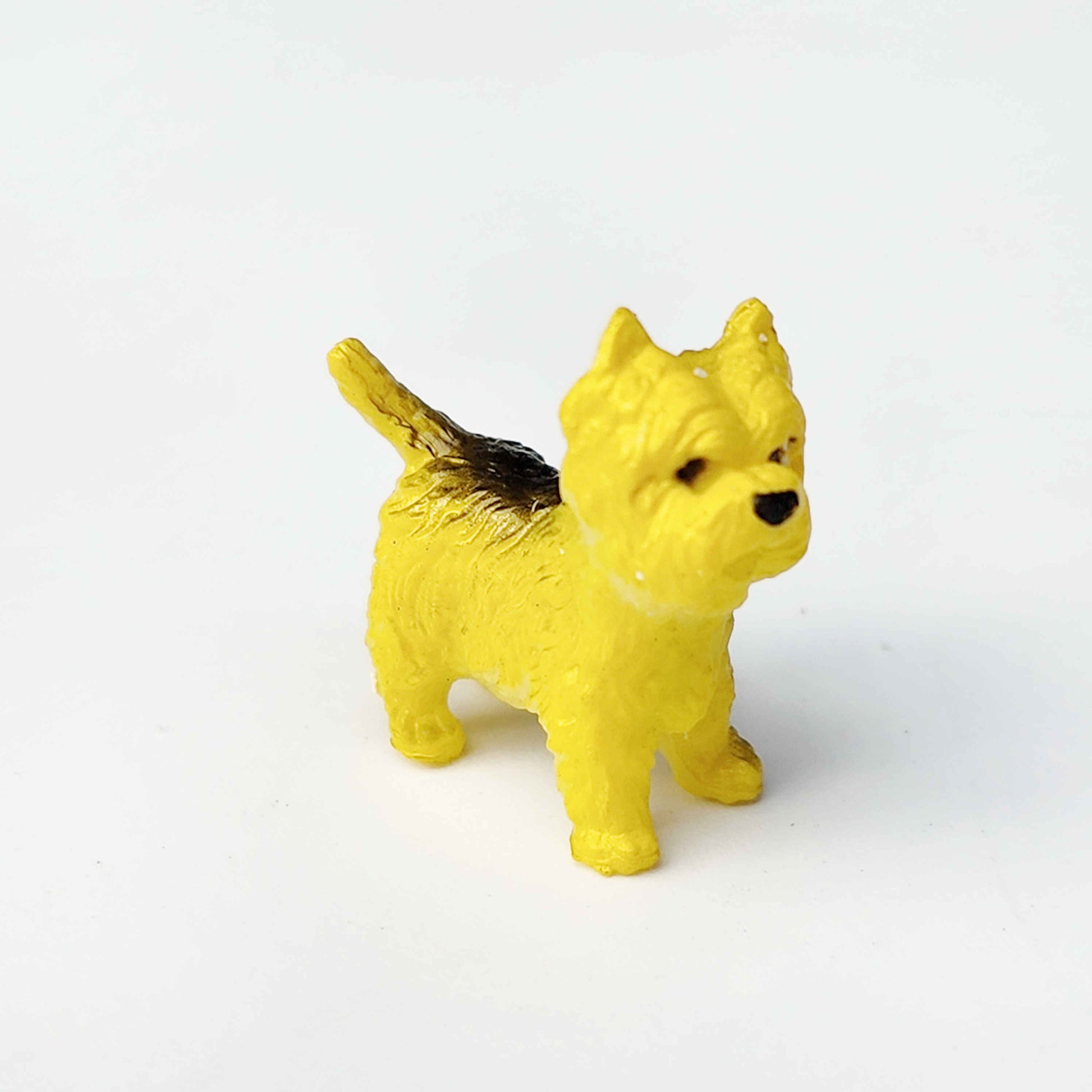Yellow terrier figurine on a plain white background