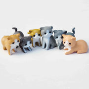 Half circle of small PVC cat figurines on a white background