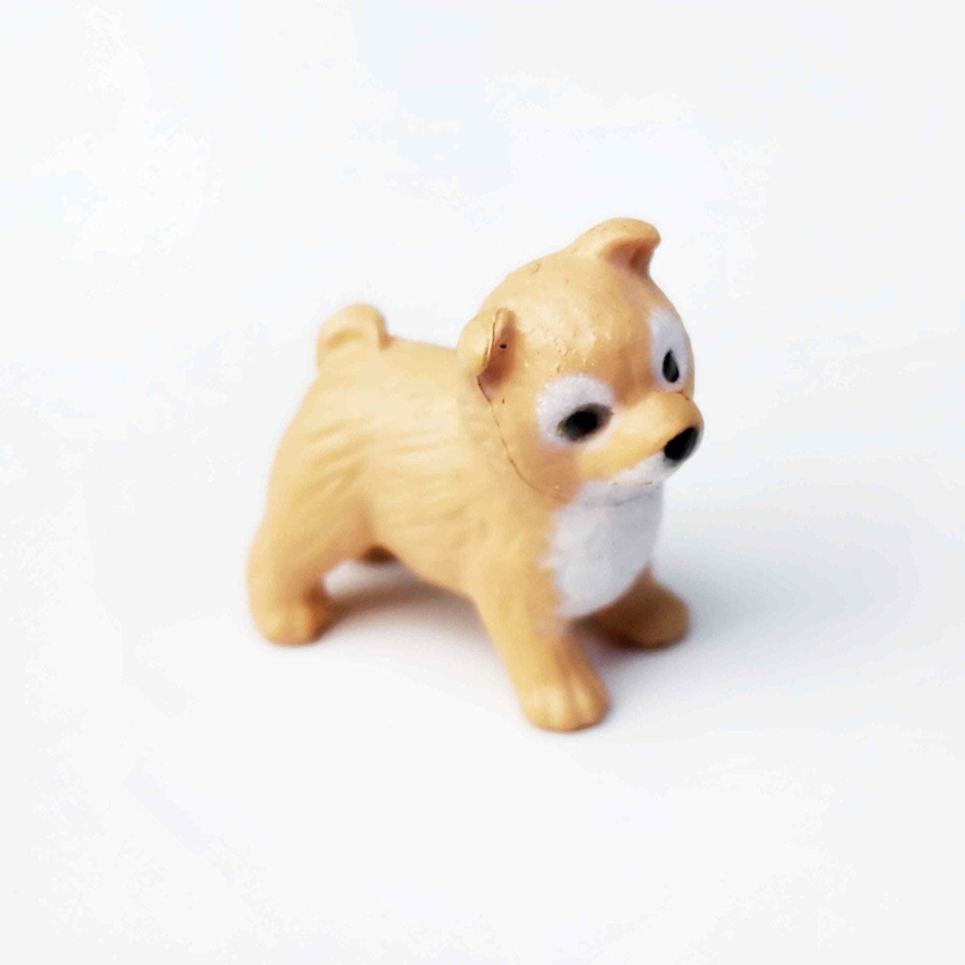 a pvc figurine of a shiba dog on a plain white background