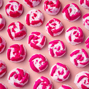 Pink and white Peony Rose mini bath bombs arranged on a pink background