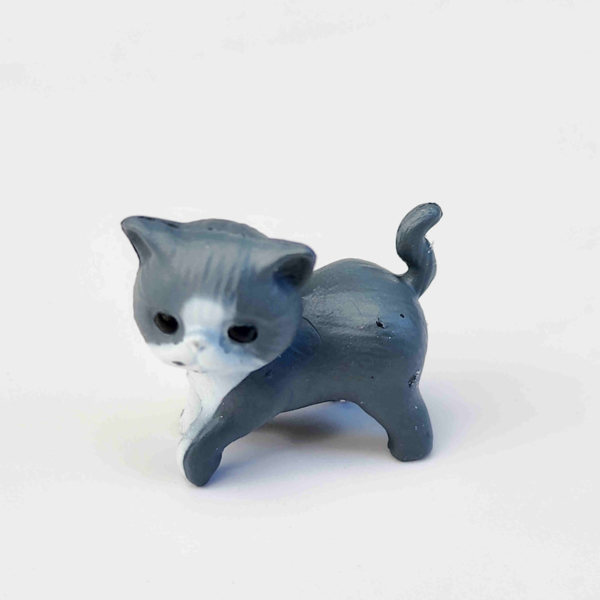 small dark grey coloured PVC cat figurine on a white background