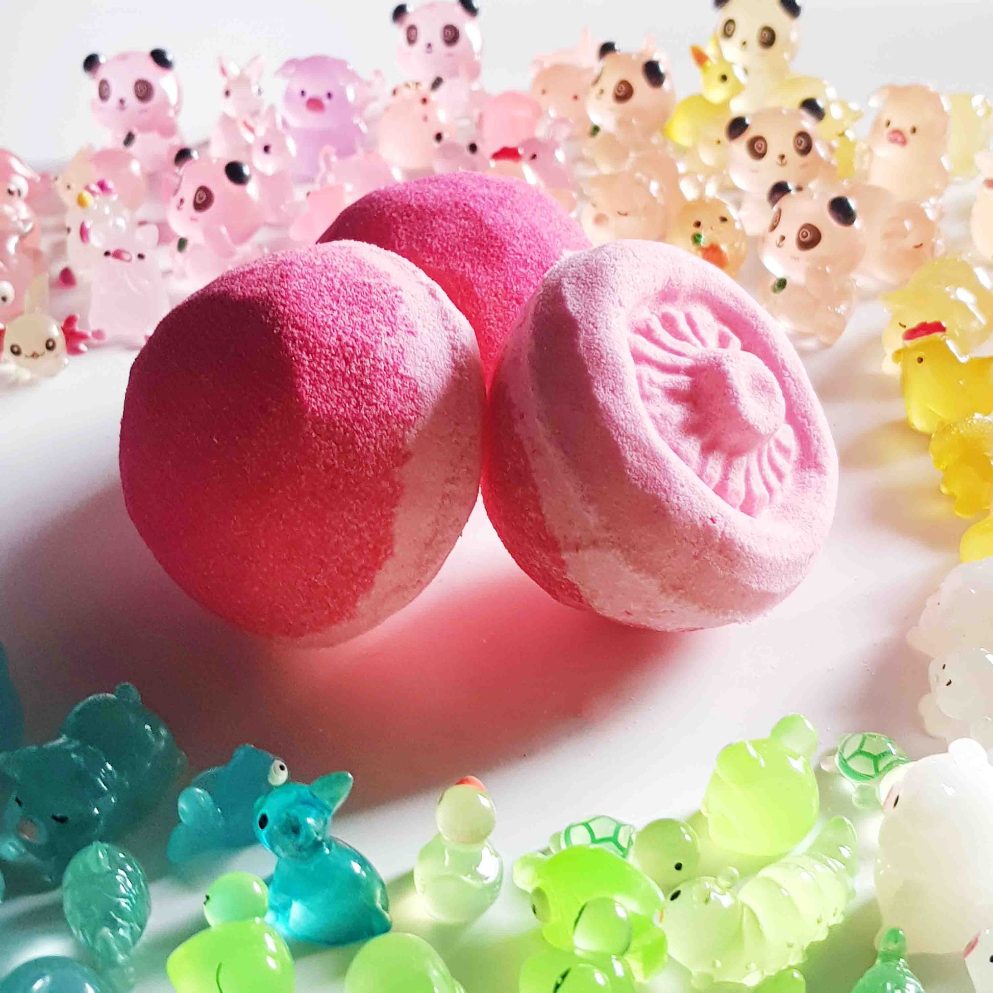 Two pink mushroom bath bombs with translucent fairy garden toys