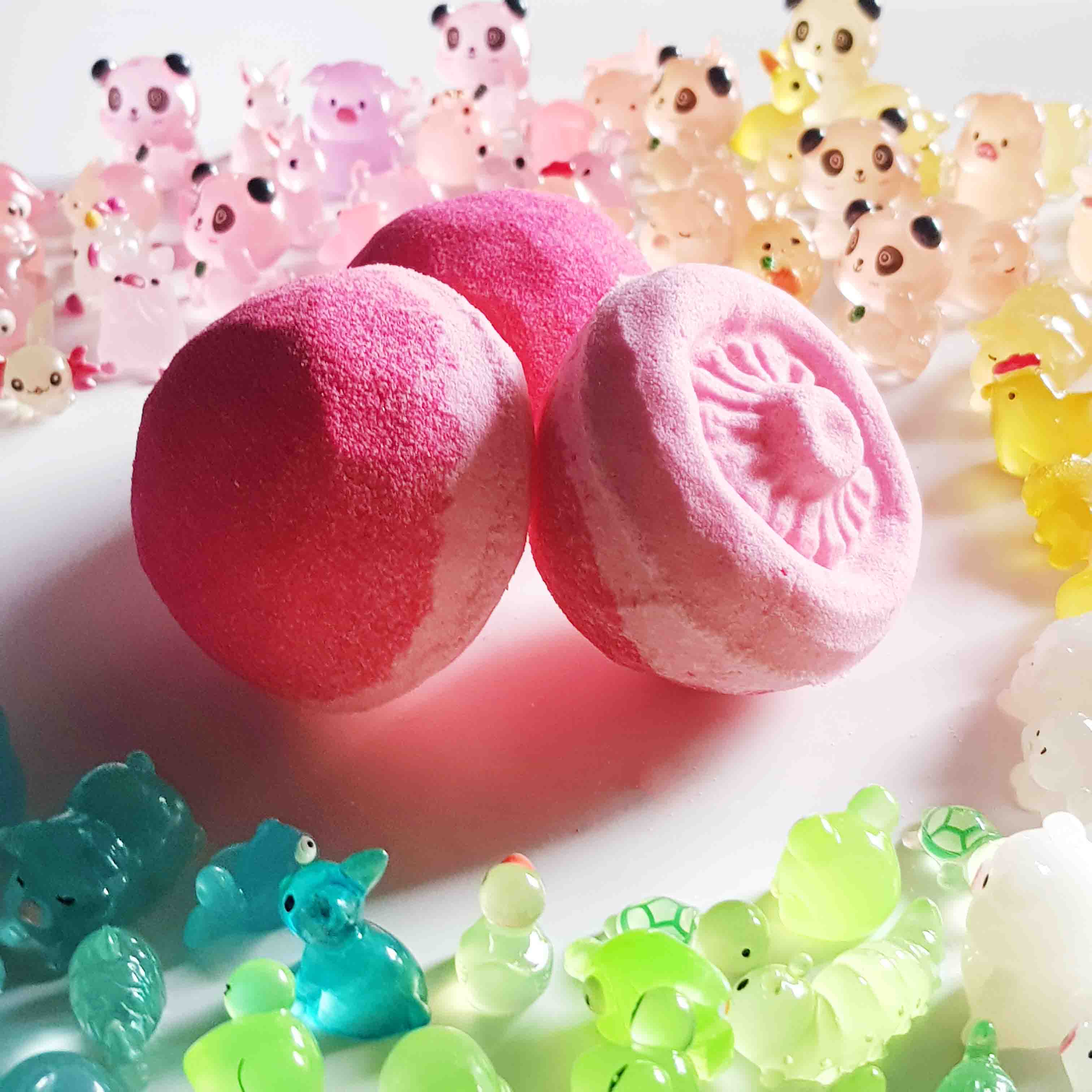 Two pink mushroom bath bombs with translucent fairy garden toys