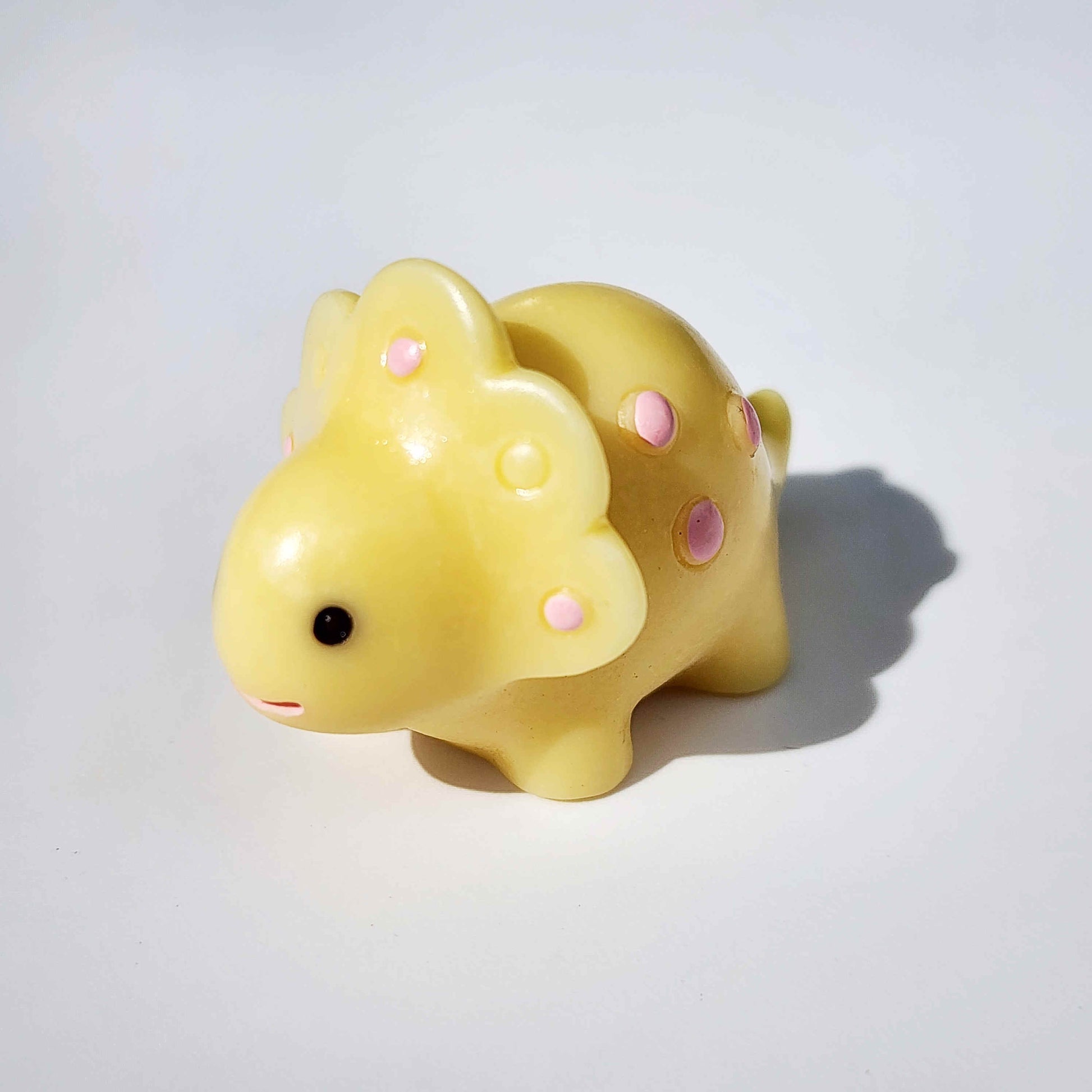 warm yellow coloured round dinosaur on a white background