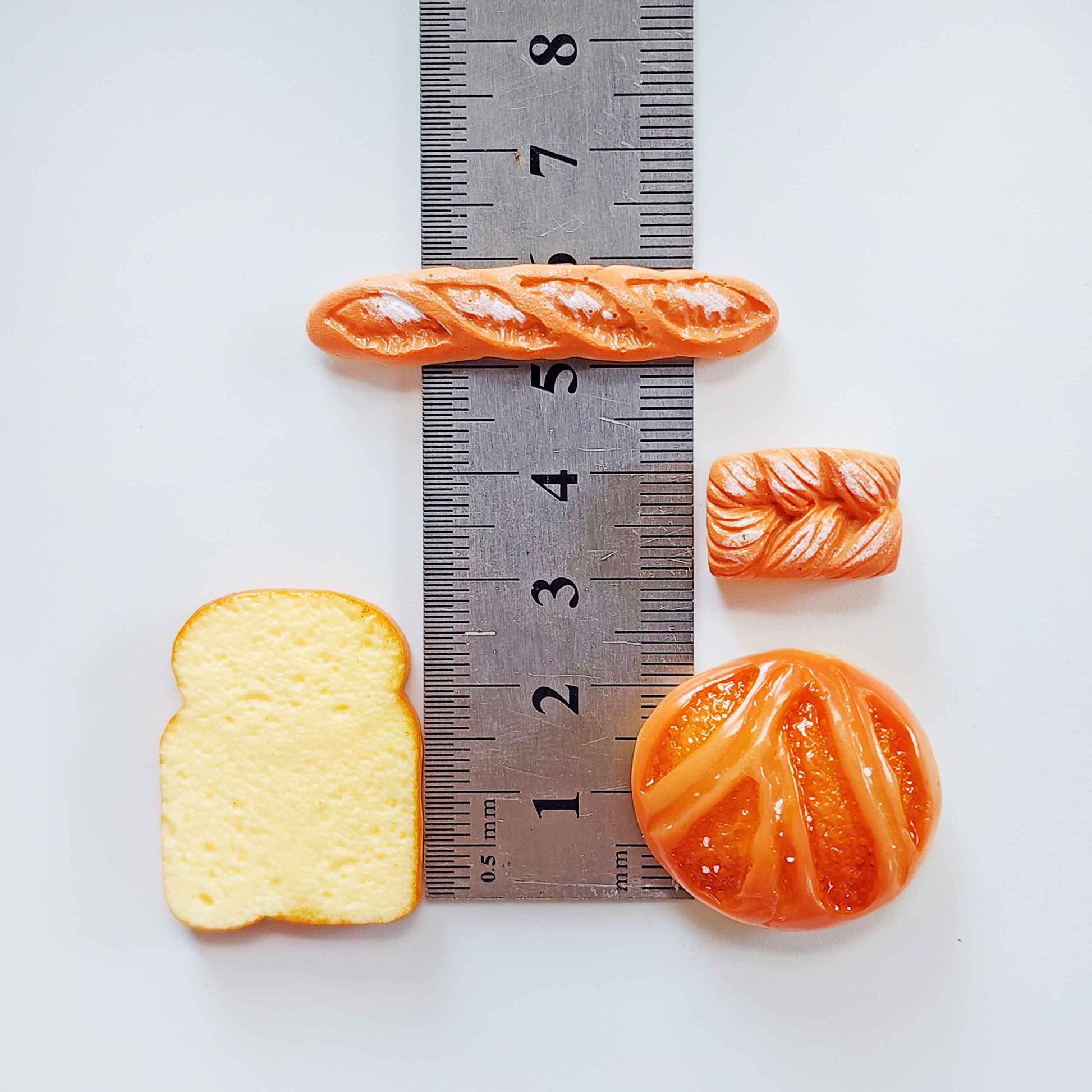 Miniature bread surprise toys measured beside a ruler