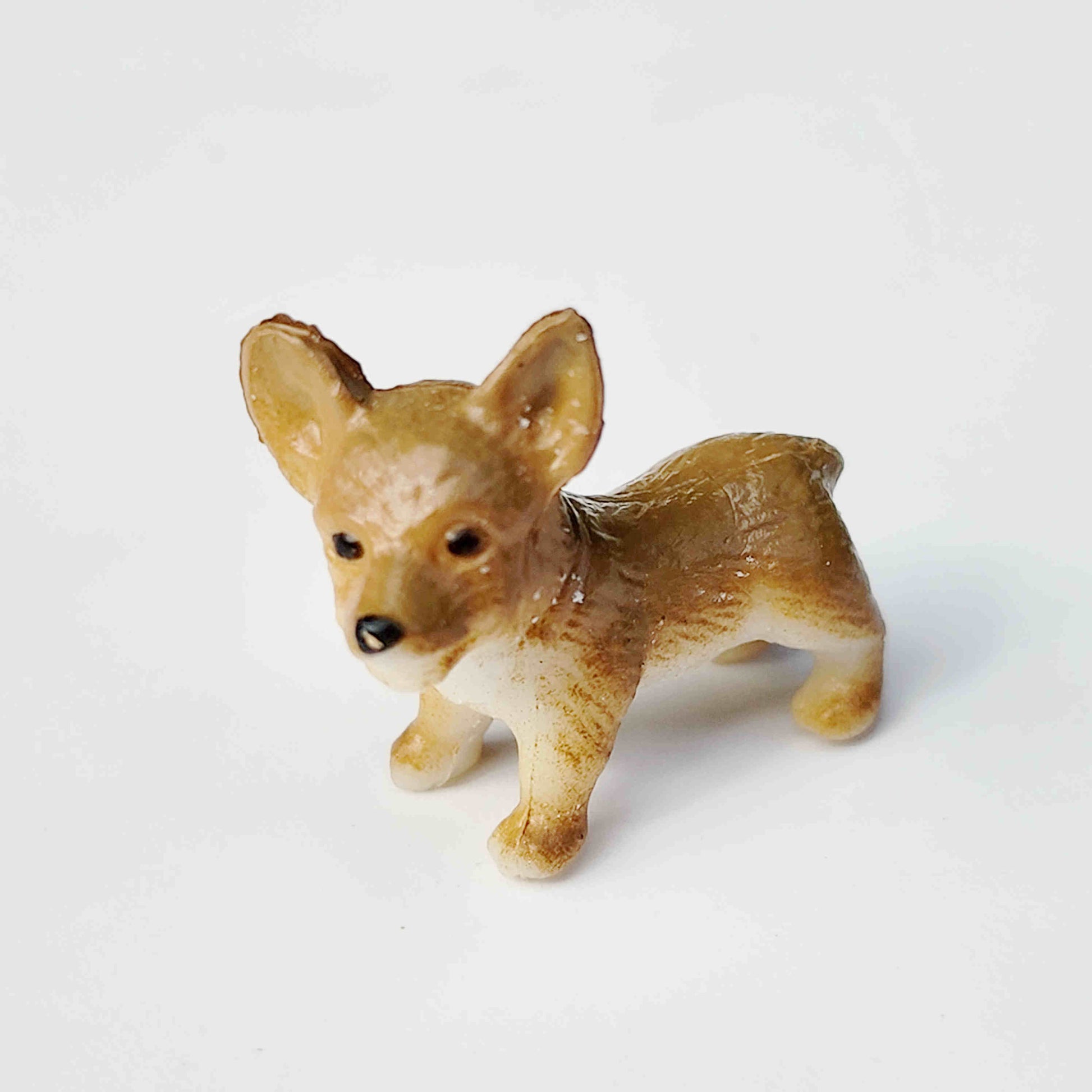 Brown puppy dog figurine placed on a plain white background