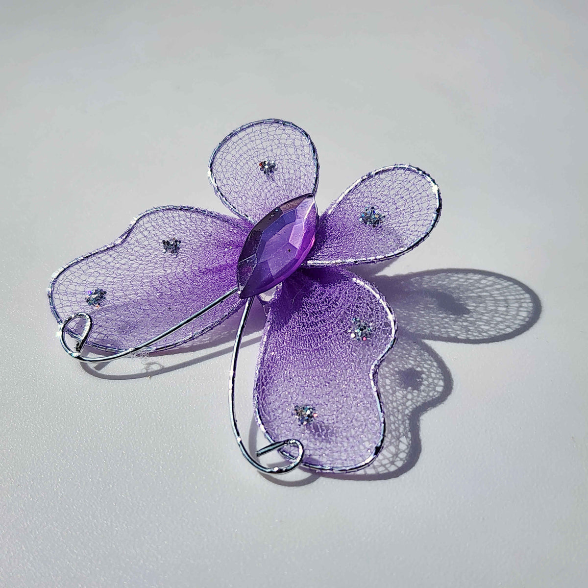 purple butterfly made of mesh fabric and wireon a white background
