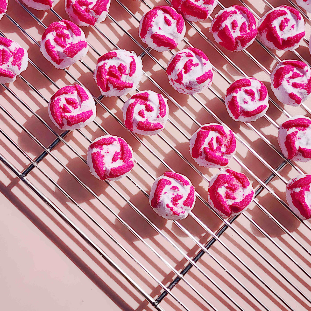Peony Rose mini bath bombs cooling on a metal rack