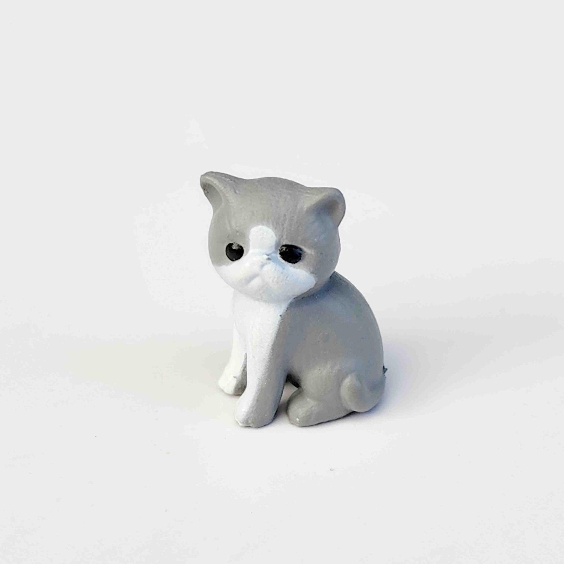 small grey coloured PVC cat figurine on a white background