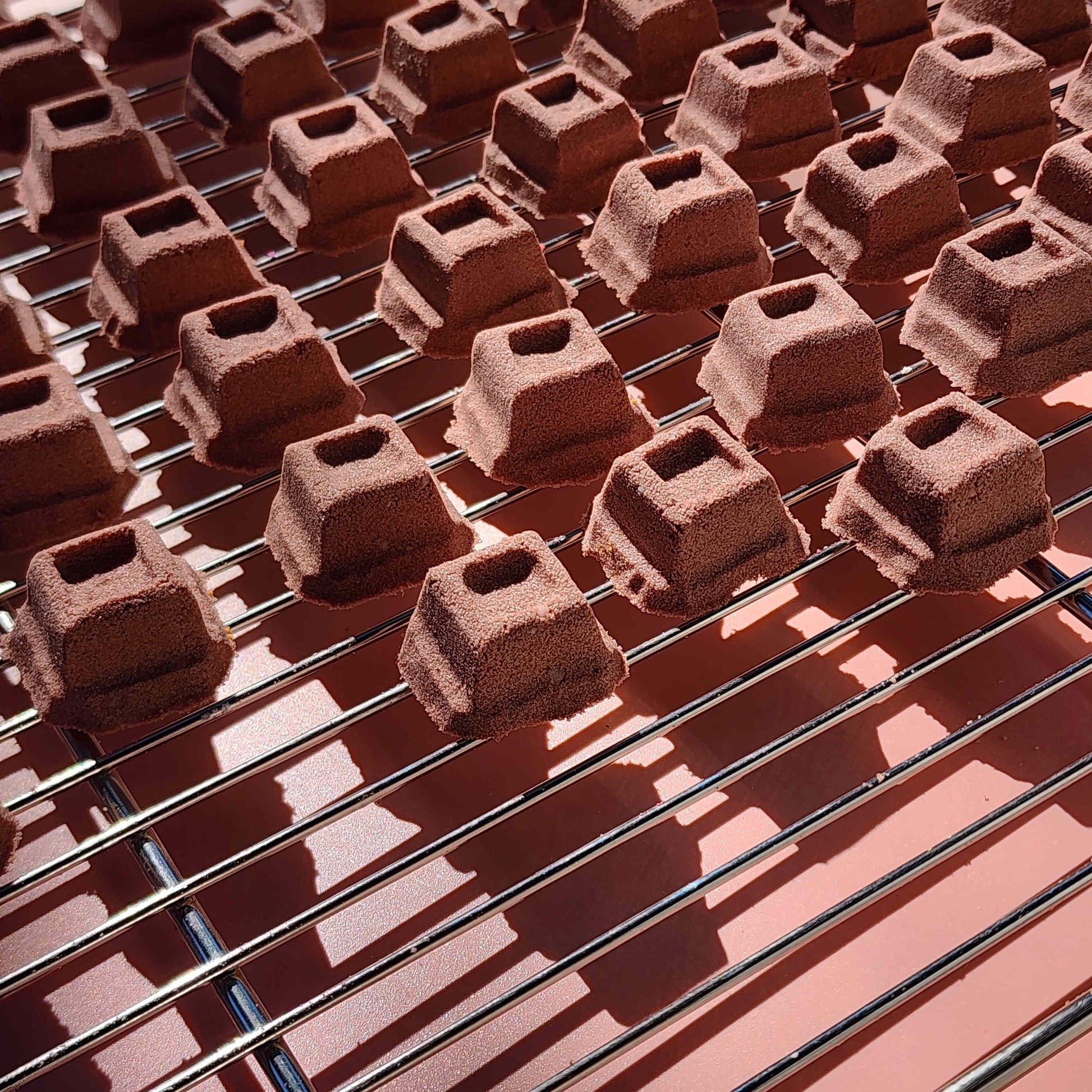 mini chocolate bath bombs shaped like cubes of chocolate on a plain brown background