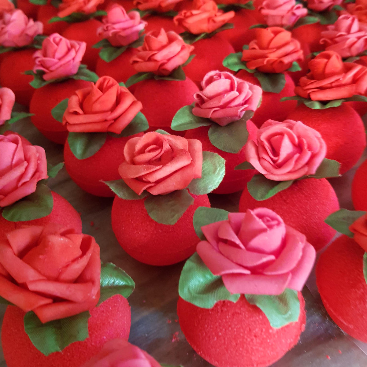 Red circular bath bomb with a rose on top