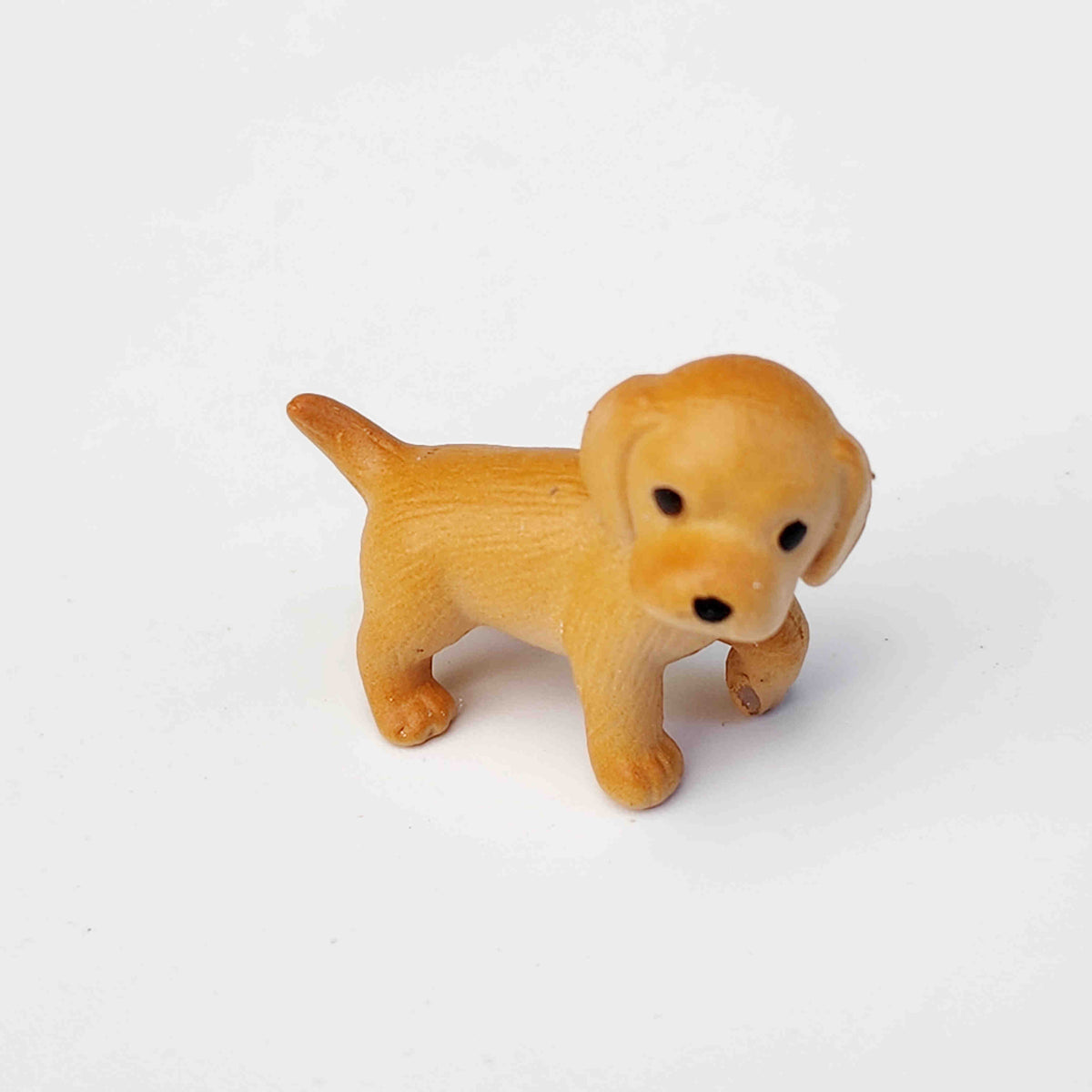 Ginger coloured pvc dog figurine on a white background