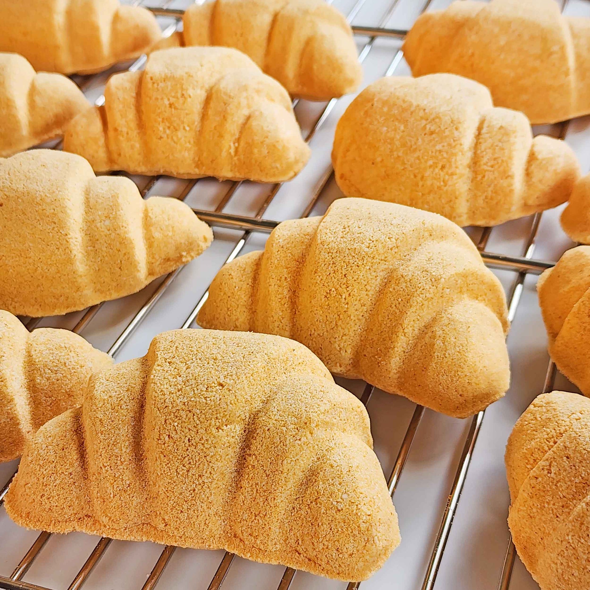 Close-up of croissant bath bombs cooling on a metal rack