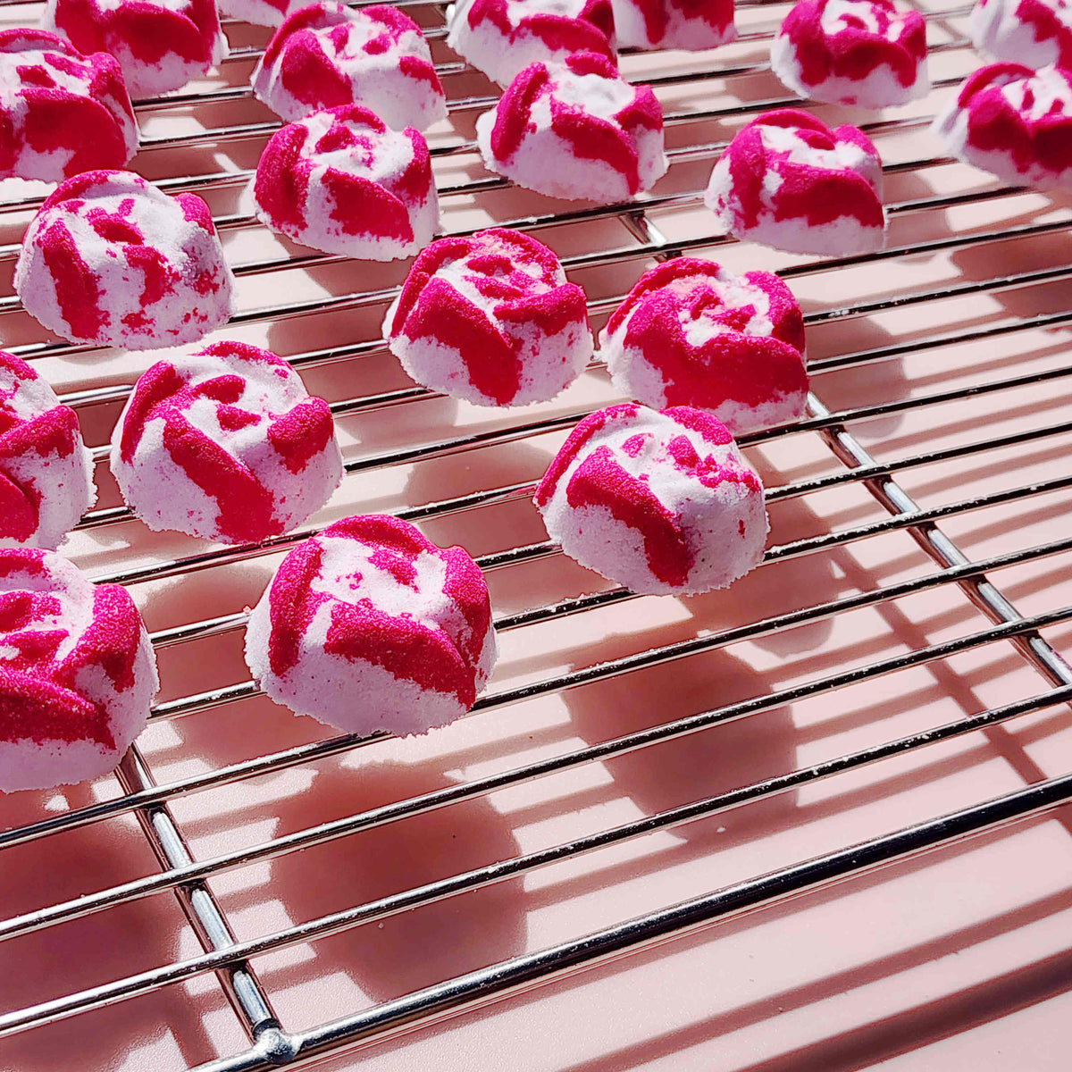 Close-up of Peony Rose mini bath bombs on a cooling rack