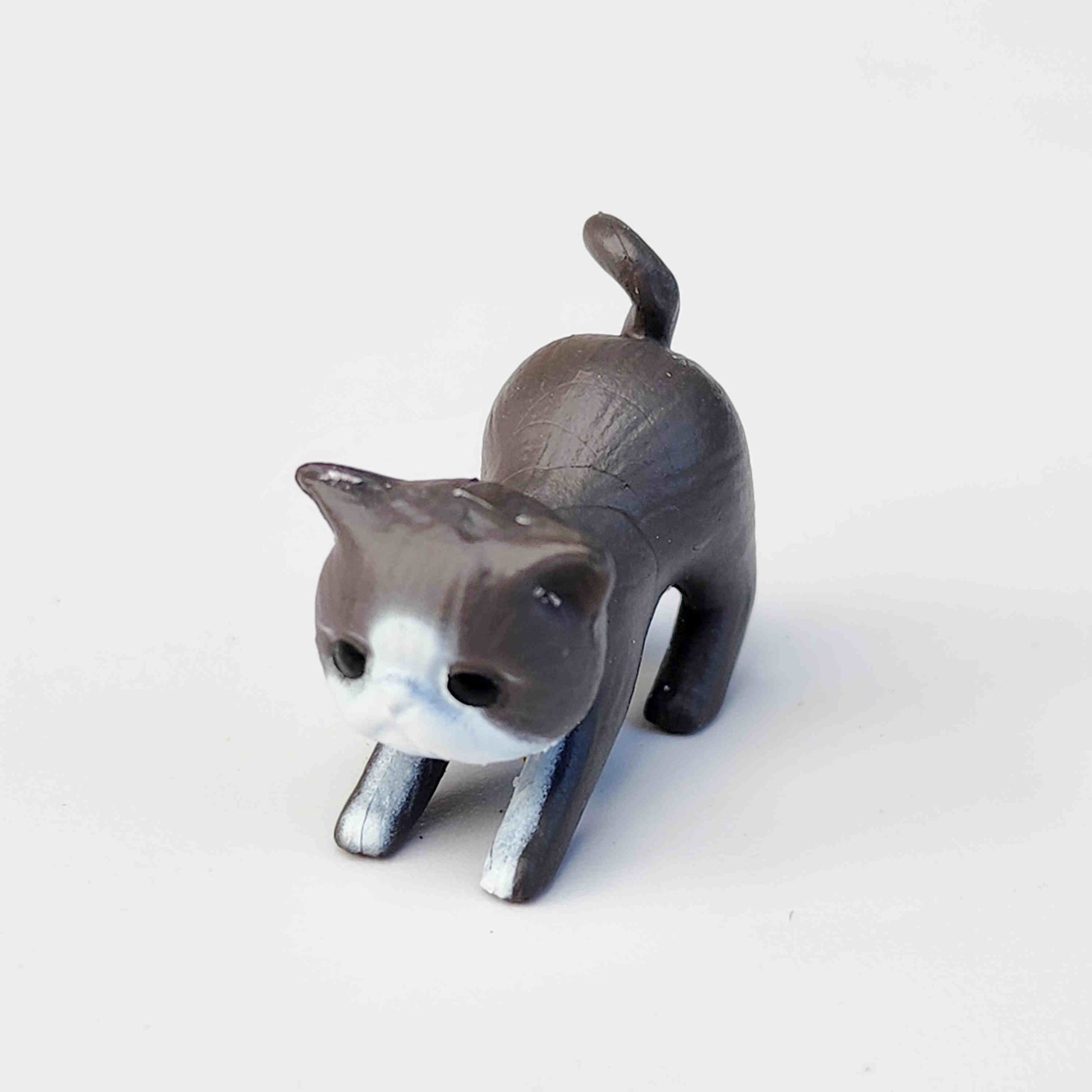 small charcoal coloured PVC cat figurine on a white background