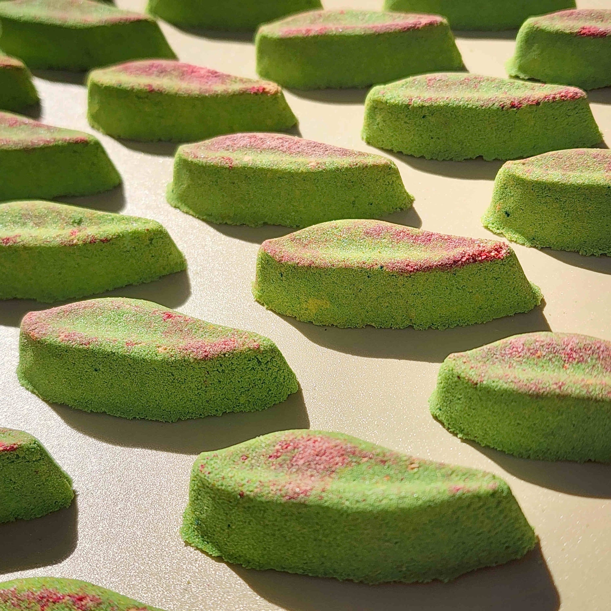 Long eucalyptus leaf shaped bath bombs on a plain beige background
