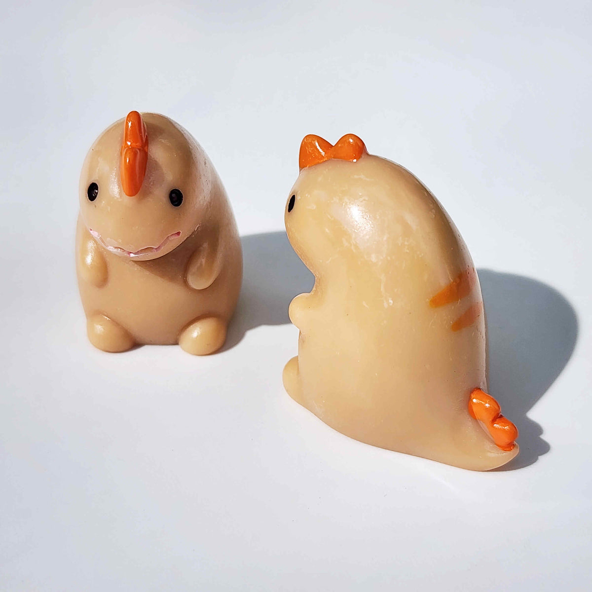 cute orange dinosaur that looks a little fat on a white background