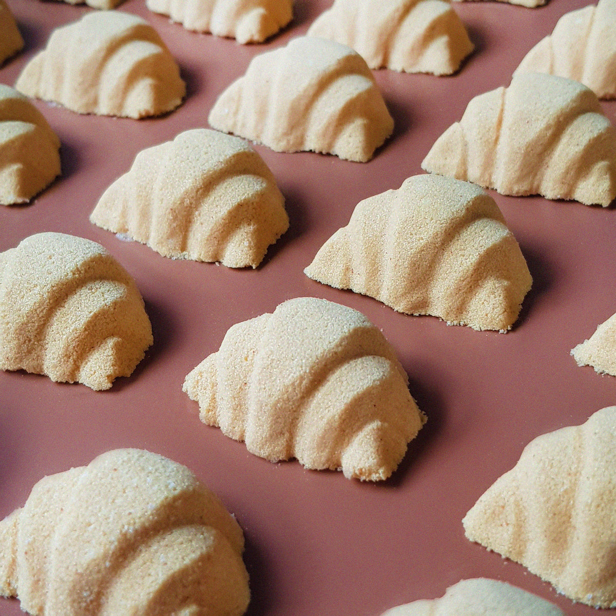 mini golden brown coloured croissant shaped bath bomb