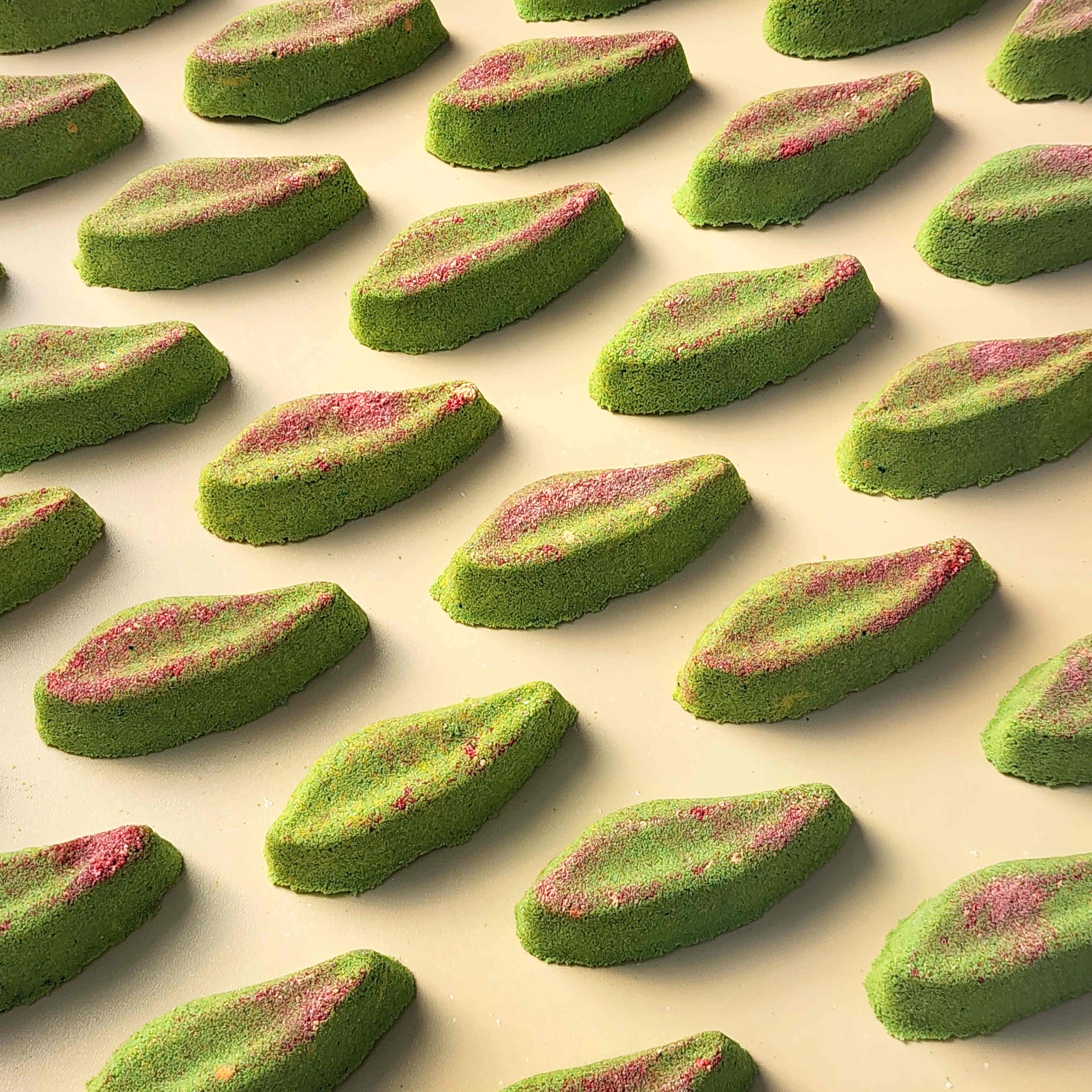 Long eucalyptus leaf shaped bath bombs on a plain beige background