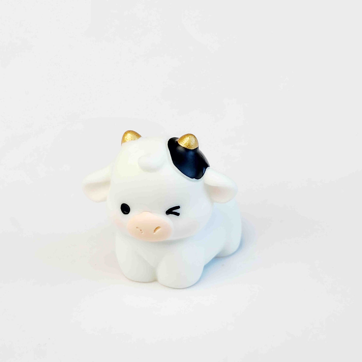 cute cow figurine with gold horns on a white background