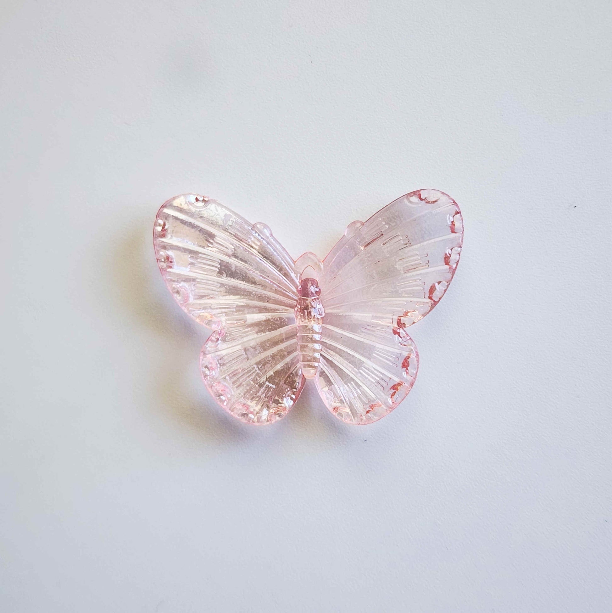 faintly pink pigmented clear iridescent butterfly charm
