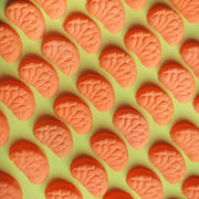 Miniature vibrant orange coloured mandarin bath bombs shaped as mini mandarin slices
