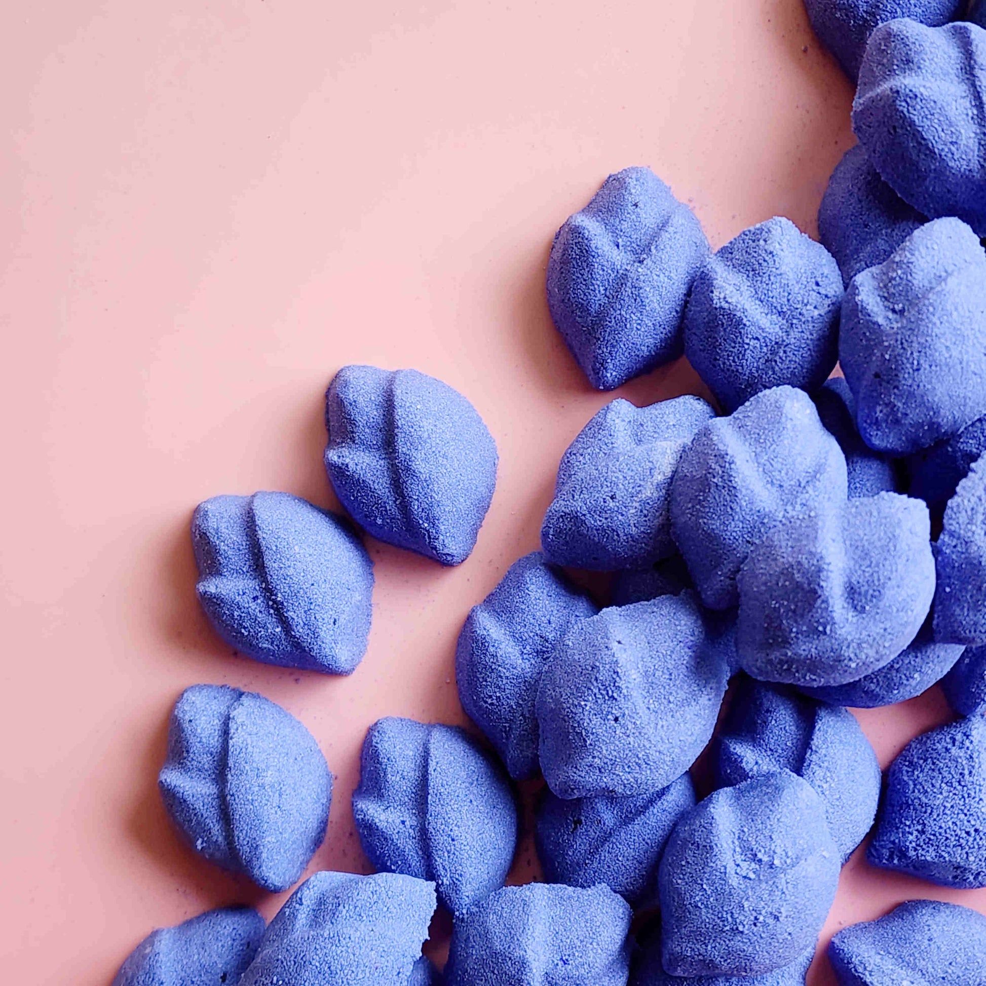 Purple lip-shaped Lavender mini bath bombs grouped in one corner