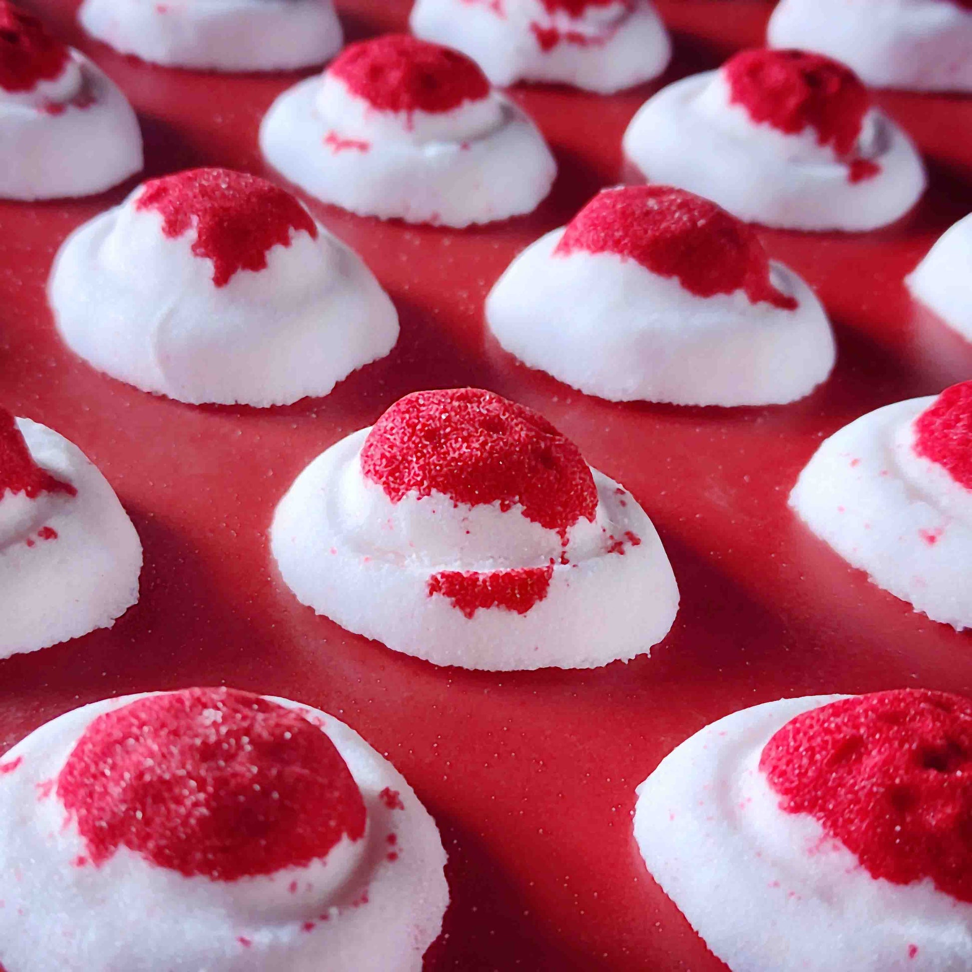 Mini red and white bath bomb inspired by the berry and cream soft lolly from the classic australian party mix