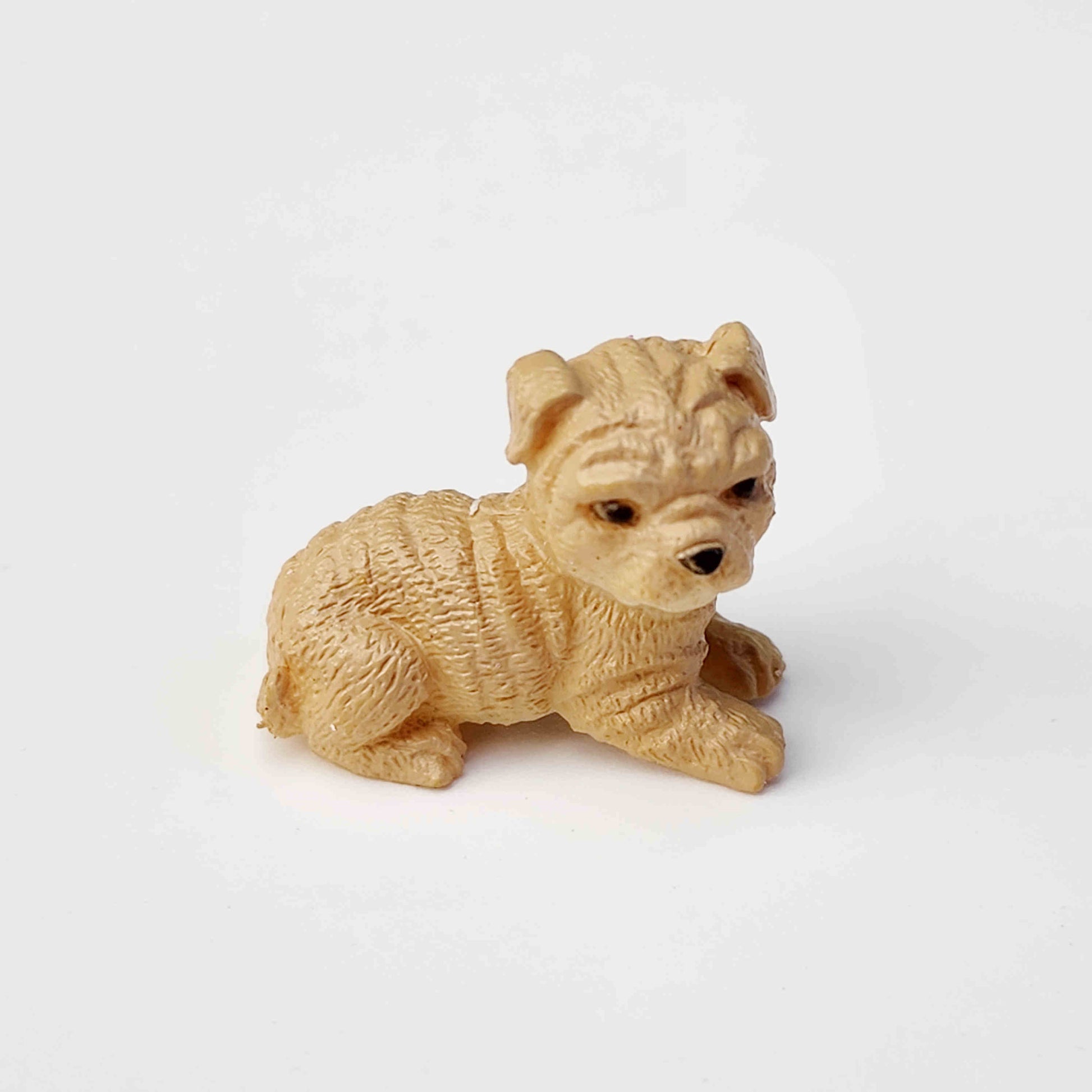 beige coloured pvc dog figurine on a white background