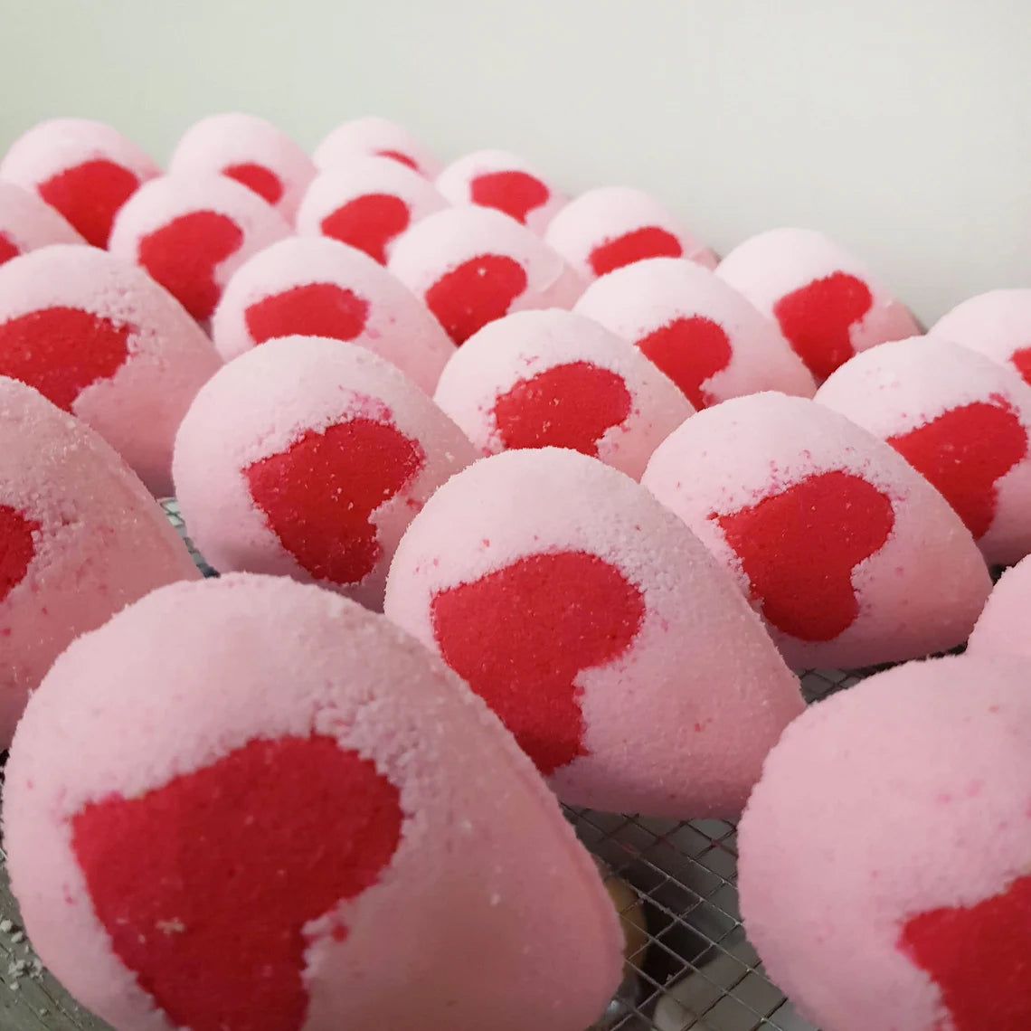 pink egg shaped bath bomb with a bright pink heart in the middle