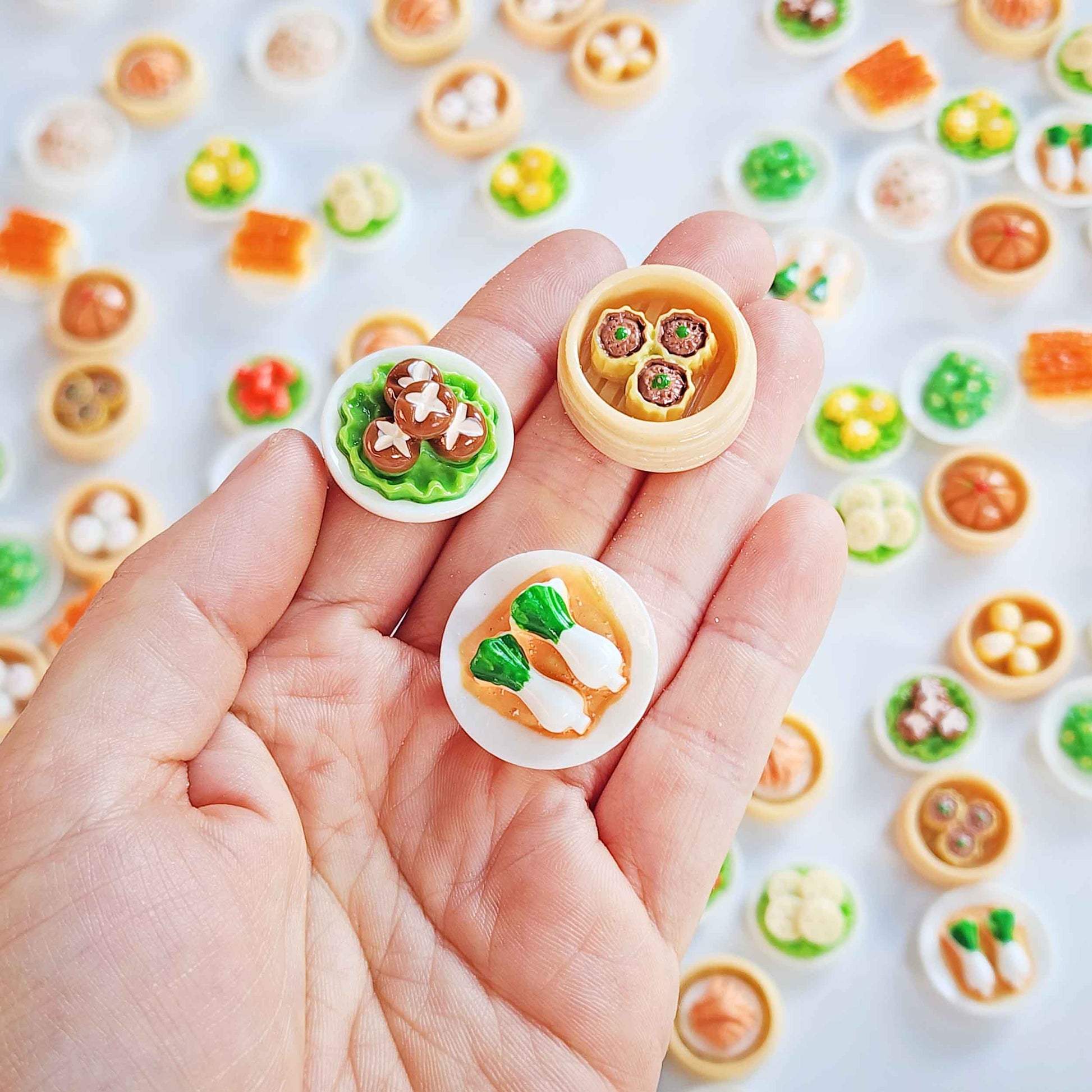 Hand holding three miniature dim sum surprise toys